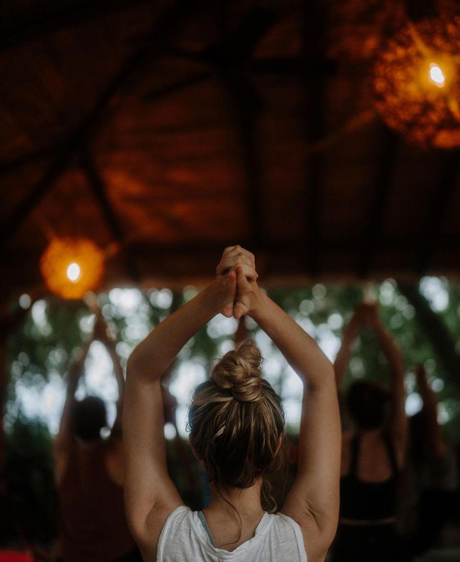 Retreat participants practicing together under a thatched roof